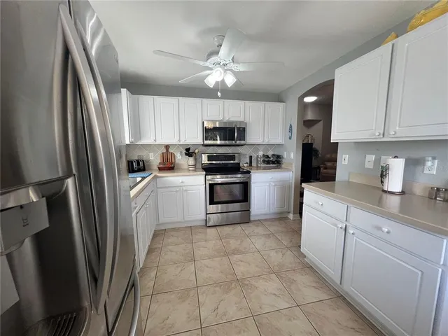 a kitchen with white cabinets and white appliances