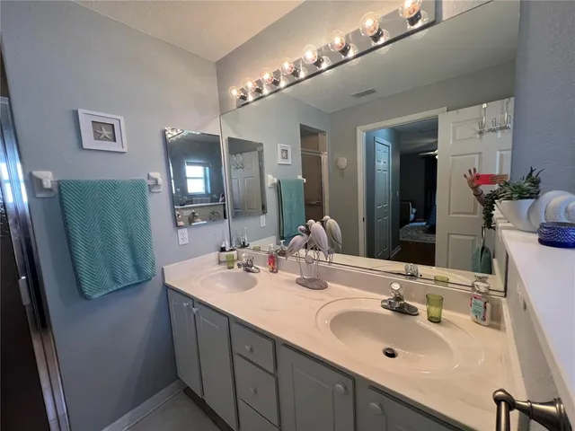 a bathroom with double vanity sink and a mirror