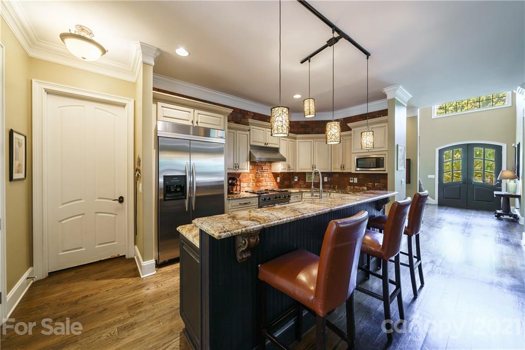 17405 Sail View Drive Cornelius, NC 28031 - Photo 10 of 43 a kitchen with stainless steel appliances kitchen island granite countertop a table chairs and a refrigerator