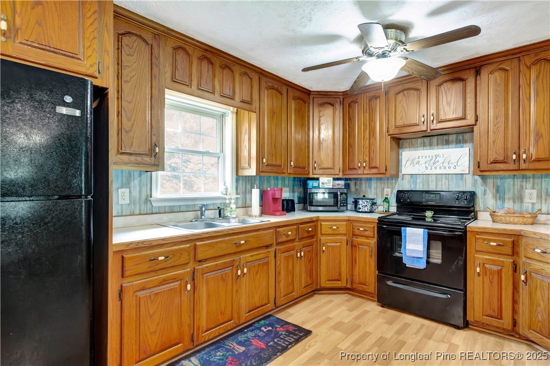 1079 Charlie Williamson Road Whiteville, NC 28472 - Photo 14 of 35 a kitchen with stainless steel appliances granite countertop a sink a stove cabinets and wooden floor
