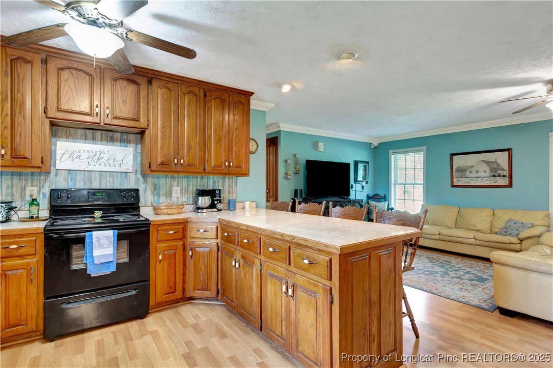 1079 Charlie Williamson Road Whiteville, NC 28472 - Photo 15 of 35 a large kitchen with stainless steel appliances granite countertop a stove top oven a sink dishwasher a dining table and chairs with wooden floor