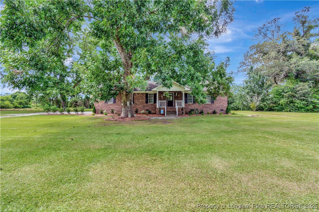 1079 Charlie Williamson Road Whiteville, NC 28472 - Photo 2 of 35 a view of a house with a backyard porch and sitting area