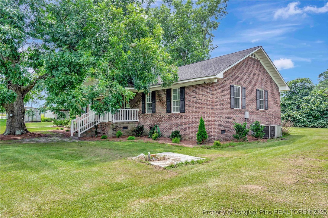 1079 Charlie Williamson Road Whiteville, NC 28472 - Photo 3 of 35 a house that is sitting in the grass with large trees and plants