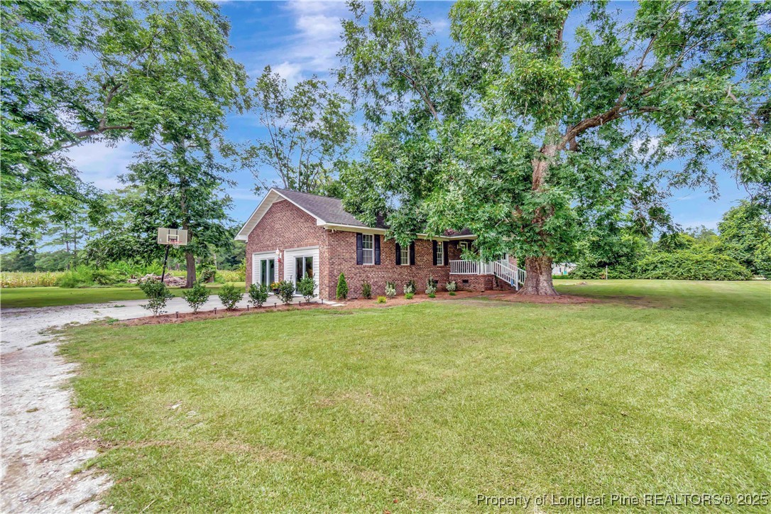 1079 Charlie Williamson Road Whiteville, NC 28472 - Photo 4 of 35 a front view of a house with yard and green space