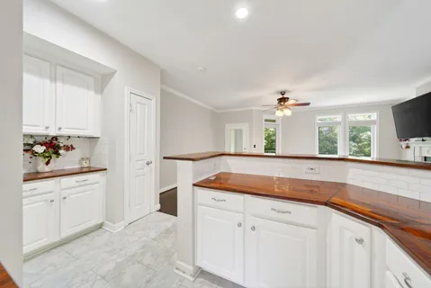a kitchen with granite countertop white cabinets and white appliances
