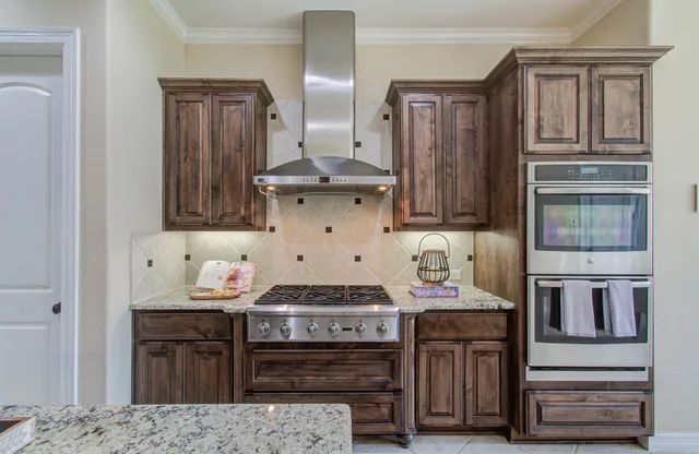 a kitchen with stainless steel appliances granite countertop a stove and cabinets