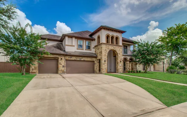 a front view of a house with a yard and trees