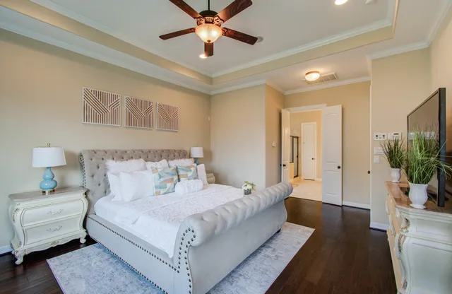 a bedroom with a large bed and a chandelier