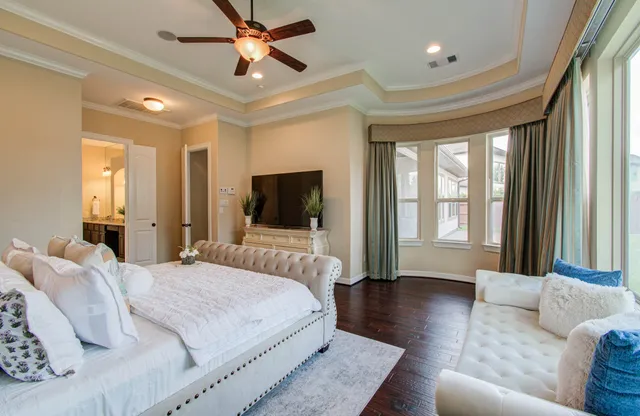 a bedroom with a bed a couch and a flat screen tv