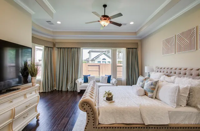 a bedroom with a large bed and a flat tv screen on dresser