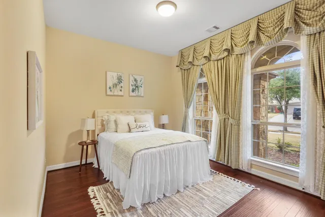 a bedroom with a bed and wooden floor