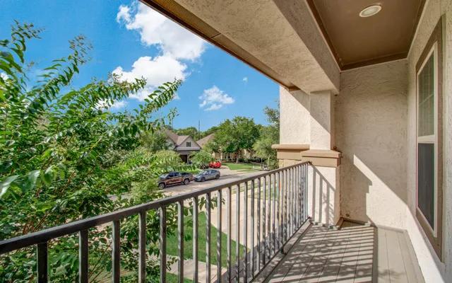 a view of a balcony with flower plants