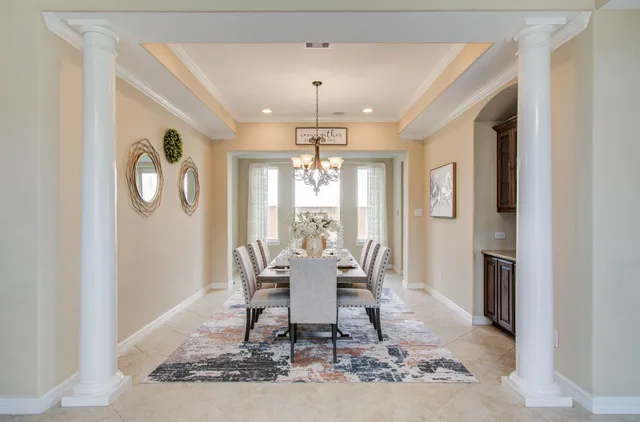 a dining room with wooden floor and a chandelier