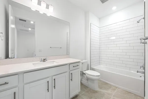 a bathroom with a granite countertop sink a toilet and shower