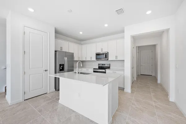 a kitchen with refrigerator and a sink
