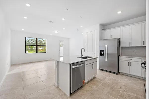 a kitchen with stainless steel appliances granite countertop a refrigerator and a stove top oven