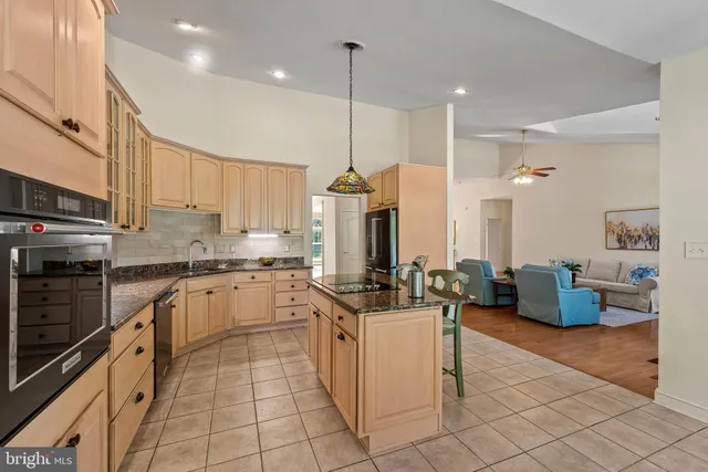 a kitchen with stainless steel appliances granite countertop a stove a sink and a refrigerator