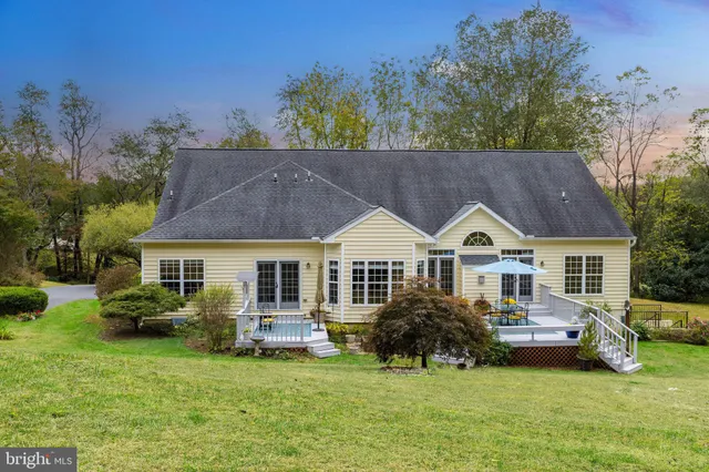 a front view of a house with a garden and trees