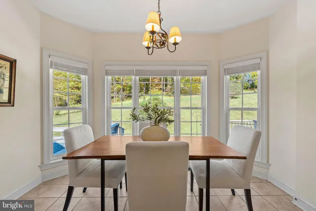 a dining room with furniture a chandelier and wooden floor