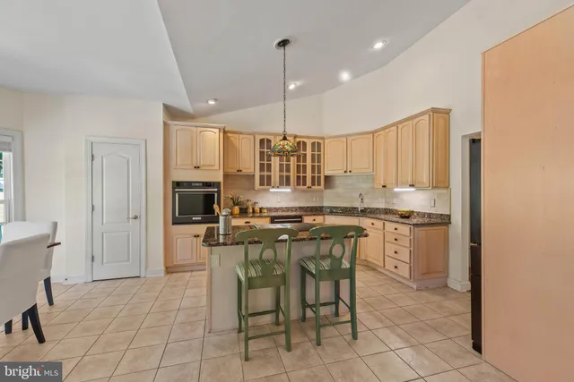 a kitchen with kitchen island granite countertop wooden cabinets stainless steel appliances a sink and a center island