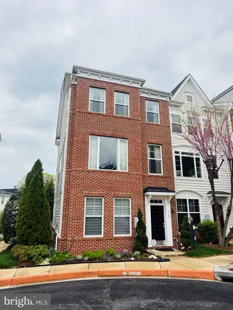 a front view of a house with yard and parking