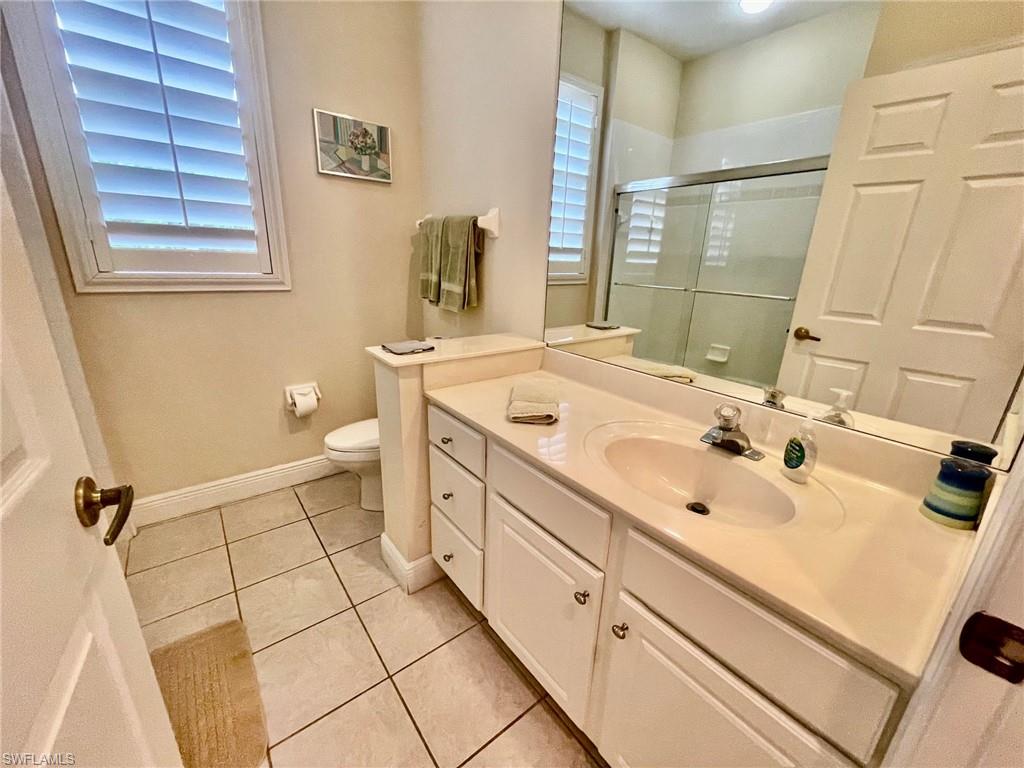 1820 Pondside Lane Naples, FL 34109 - Photo 11 of 17 a bathroom with a sink a toilet and a mirror