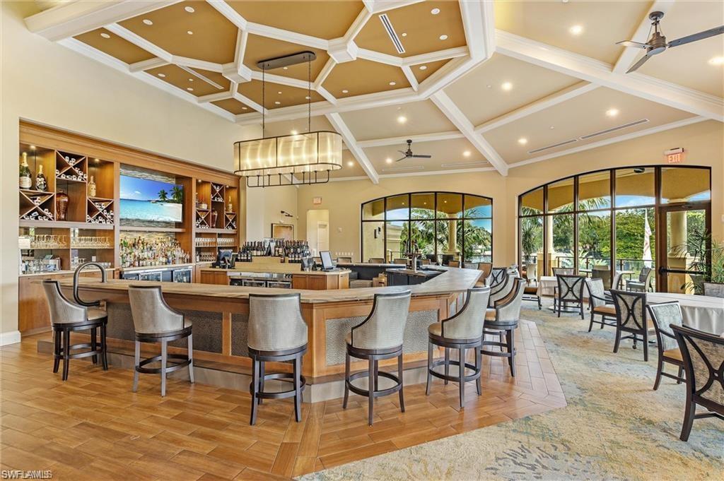 1820 Pondside Lane Naples, FL 34109 - Photo 15 of 17 a dining hall with lots of tables a large window and stainless steel appliances