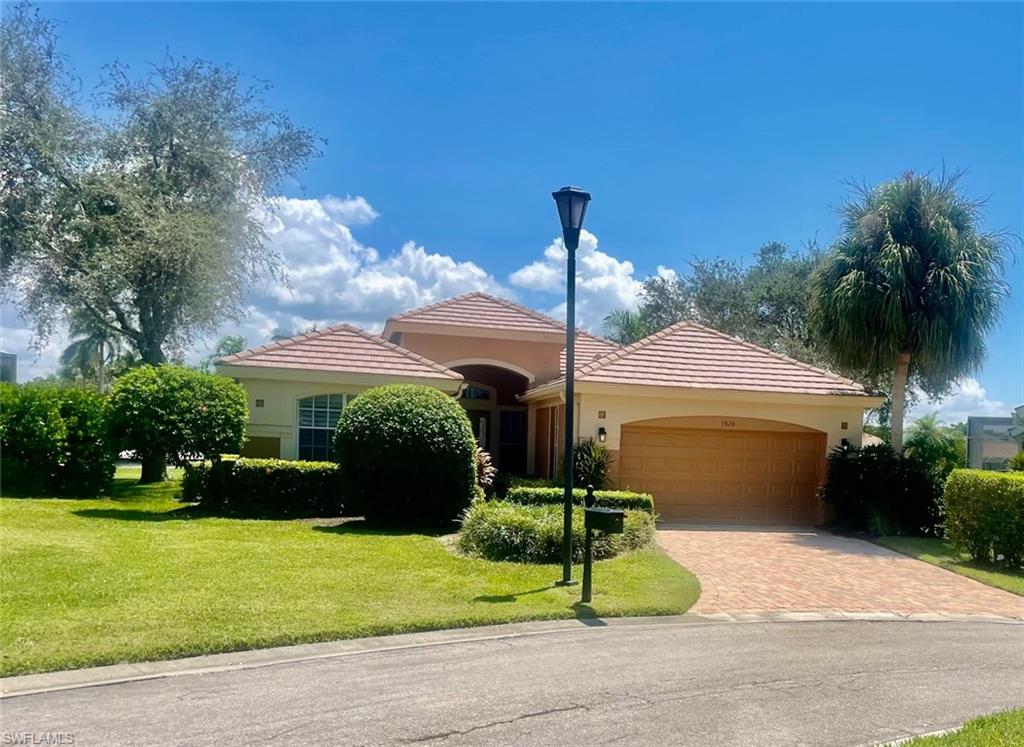 1820 Pondside Lane Naples, FL 34109 - Photo 2 of 17 a front view of a house with garden