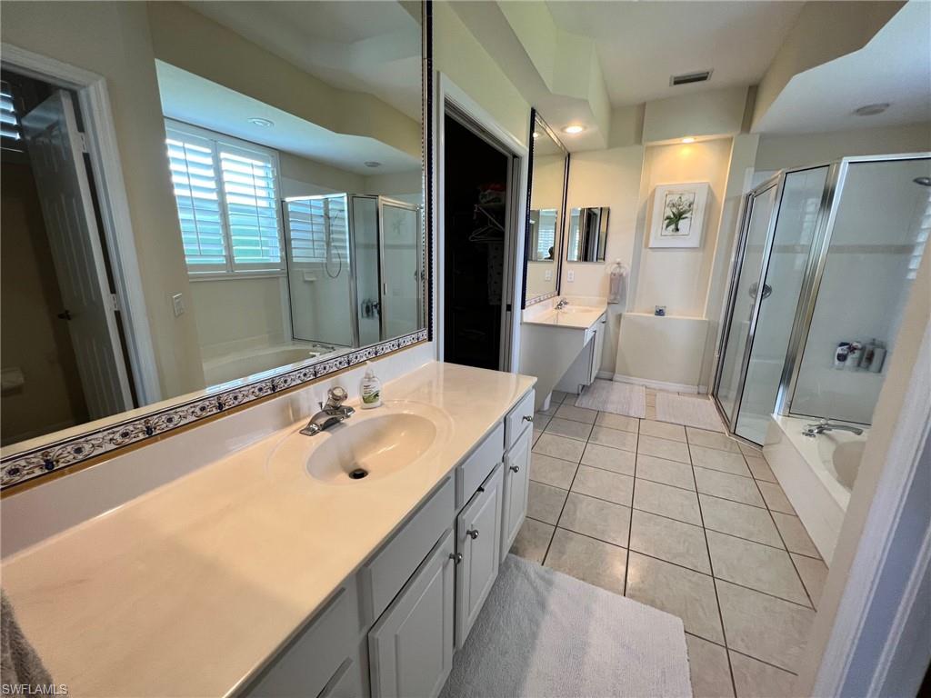 1820 Pondside Lane Naples, FL 34109 - Photo 9 of 17 a spacious bathroom with a double vanity sink a large mirror and shower