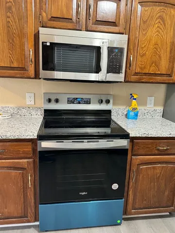 a kitchen with stainless steel appliances granite countertop a stove and a microwave