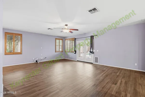 a view of an empty room with window and wooden floor