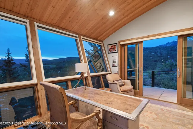 a view of a roof deck with couches under an umbrella