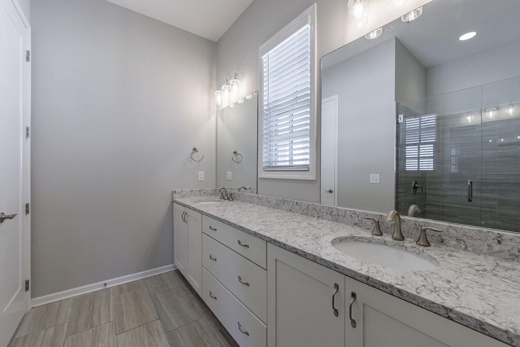 225 Britten Pass Alpharetta, GA 30009 - Photo 27 of 38 a bathroom with a granite countertop sink and a mirror
