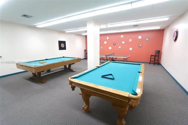 a room with pool table and windows