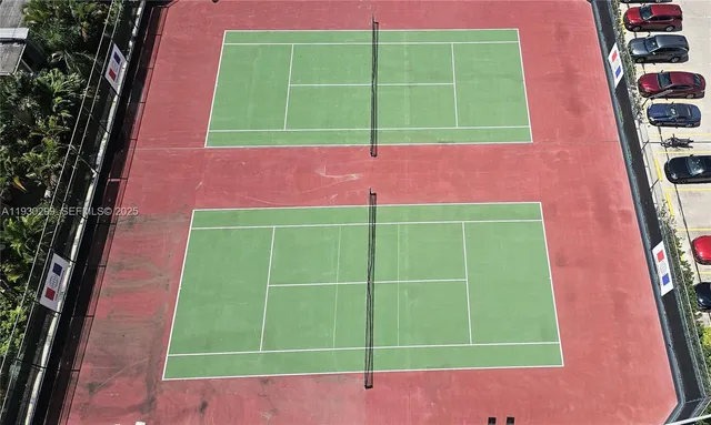 a view of a tennis ground with a small cabin