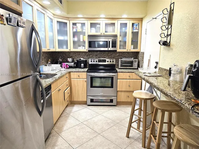 a kitchen with stainless steel appliances granite countertop a stove a sink and a refrigerator