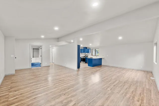 a view of empty room with wooden floor