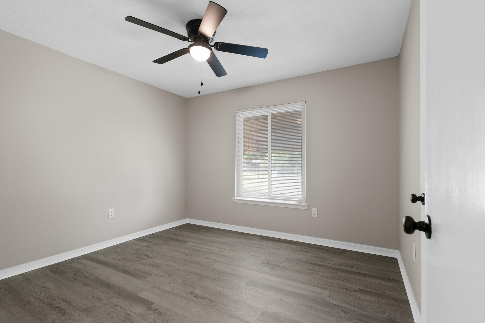 3437 Auburn Road Crestview, FL 32539 - Photo 14 of 26 an empty room with wooden floor and windows