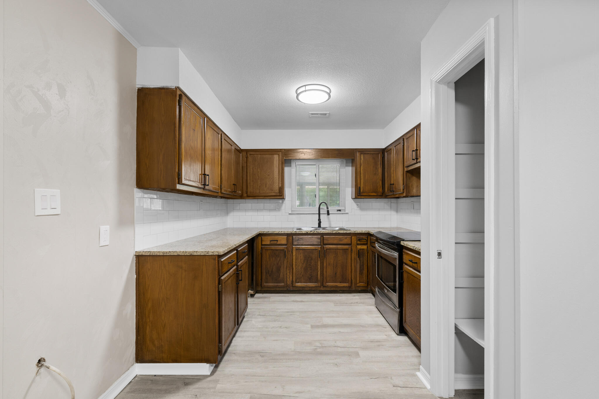 3437 Auburn Road Crestview, FL 32539 - Photo 19 of 26 a kitchen with stainless steel appliances granite countertop a sink stove and refrigerator