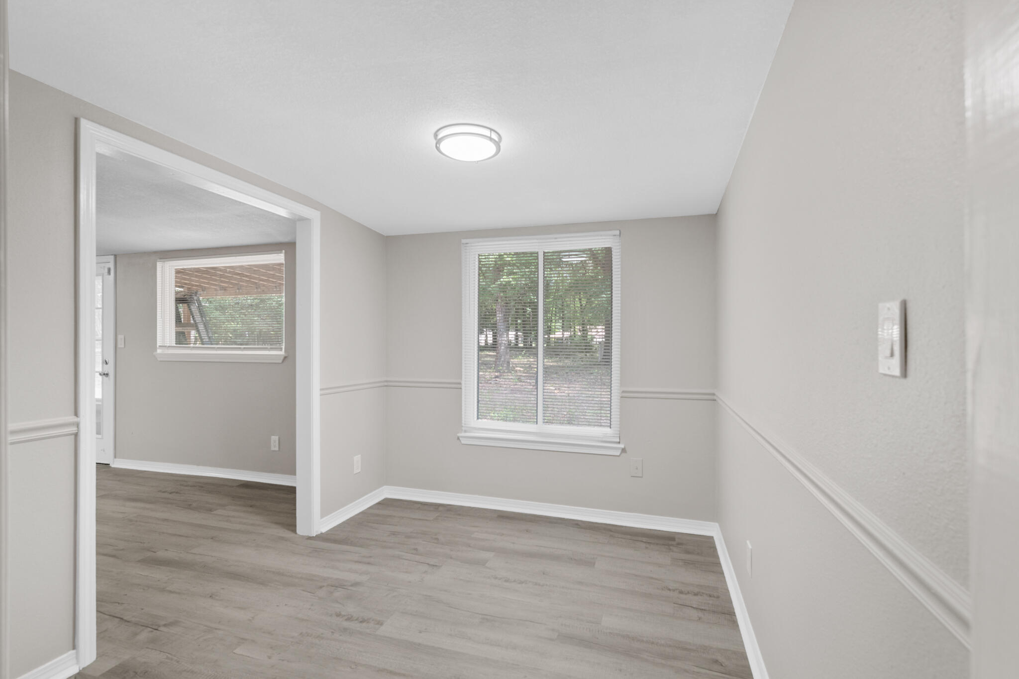 3437 Auburn Road Crestview, FL 32539 - Photo 8 of 26 an empty room with wooden floor and windows