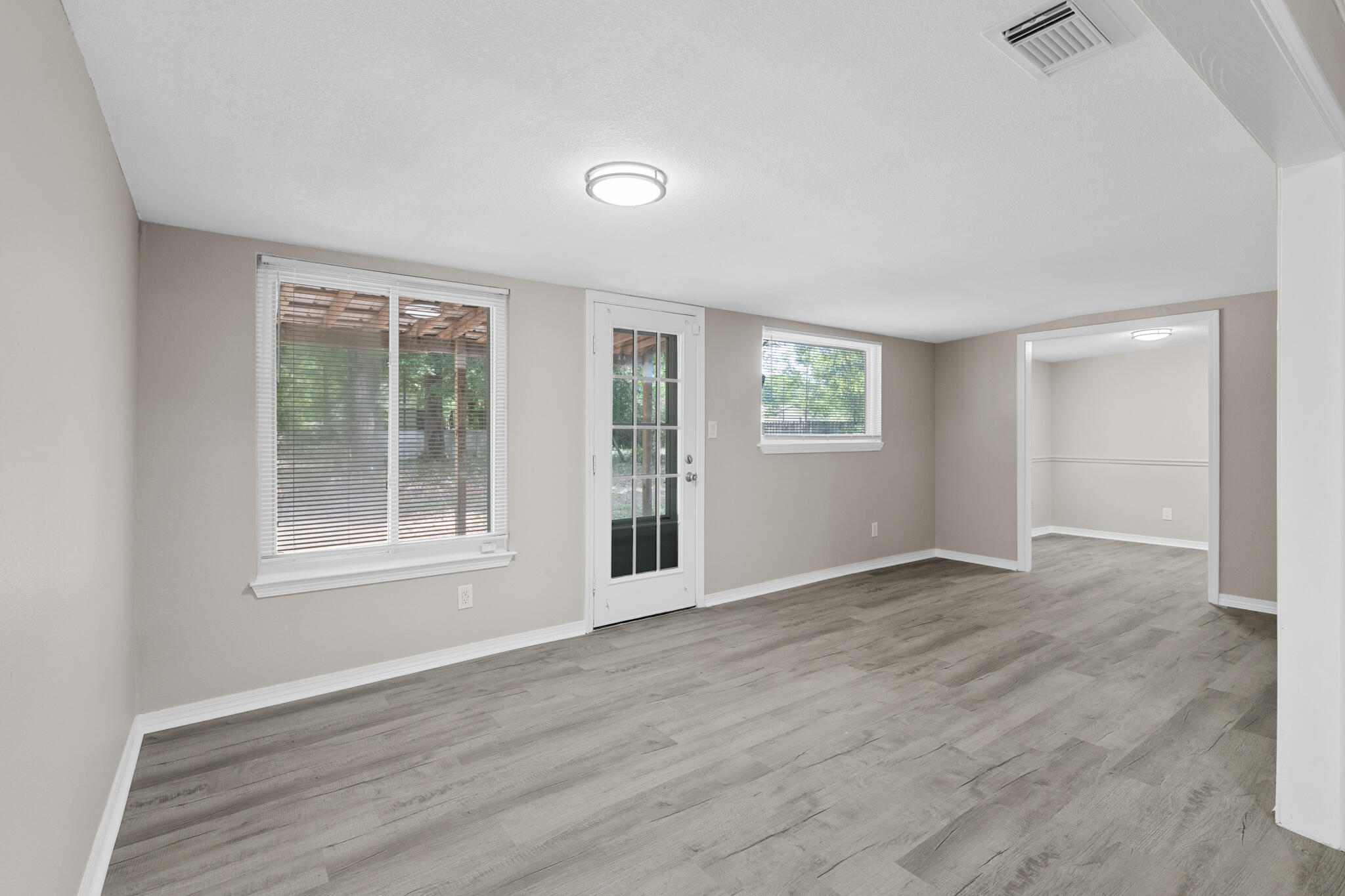 3437 Auburn Road Crestview, FL 32539 - Photo 9 of 26 an empty room with wooden floor and windows