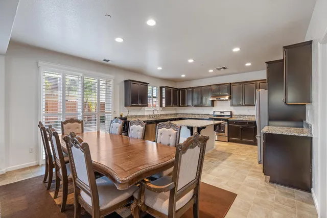 a view of a dining room with furniture and a kitchen