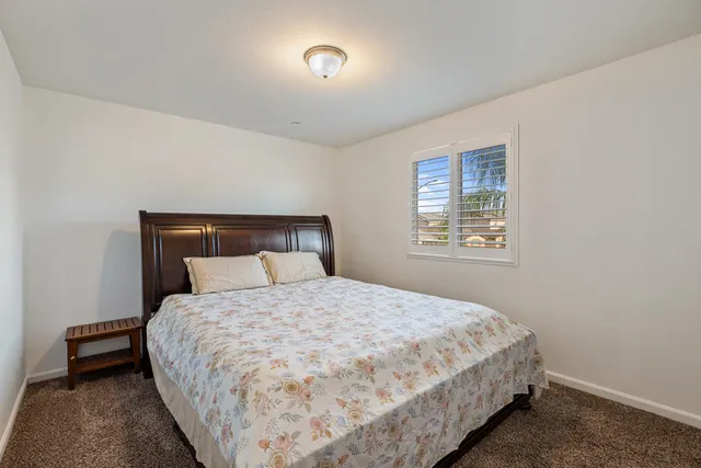a large bed sitting in a bedroom next to a window