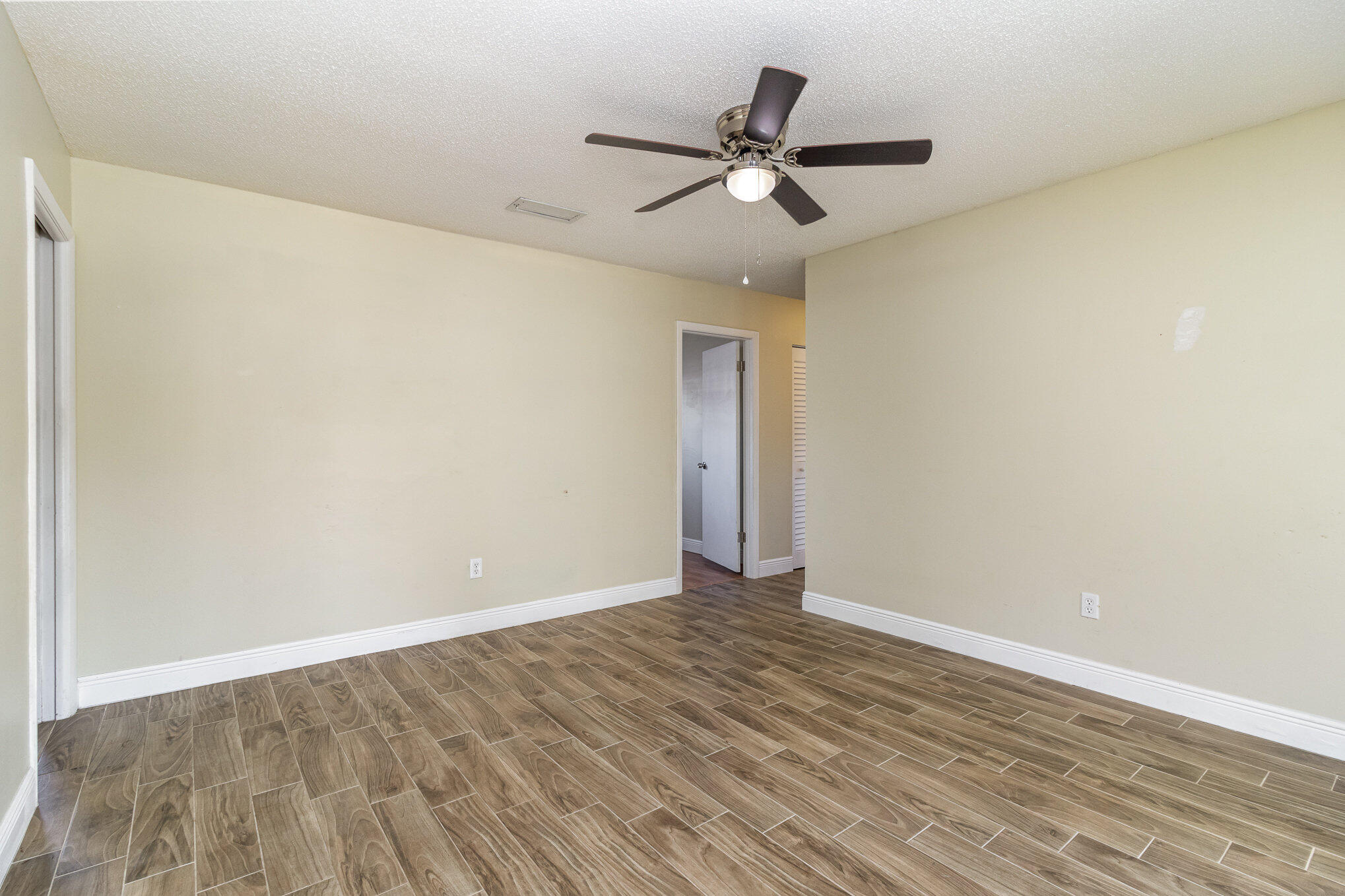 1294 Cimarron Circle Northeast Palm Bay, FL 32905 - Photo 11 of 45 a view of an empty room with wooden floor