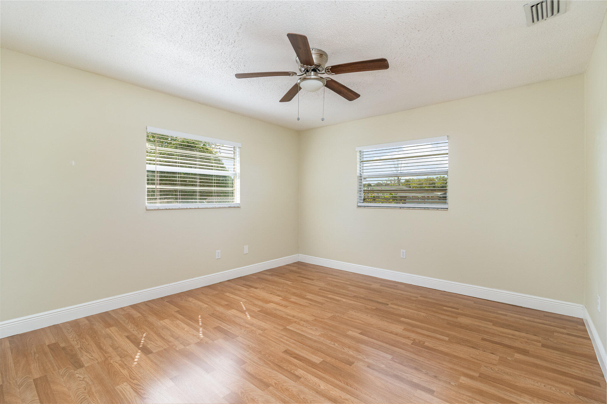 1294 Cimarron Circle Northeast Palm Bay, FL 32905 - Photo 20 of 45 a view of an empty room with a window and wooden floor
