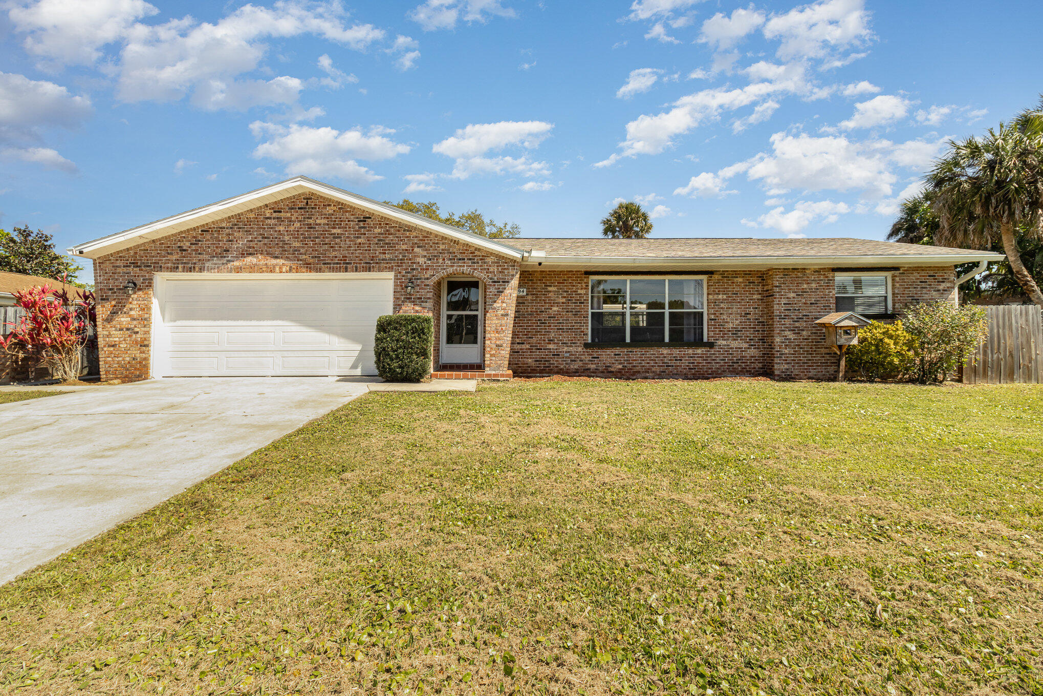 1294 Cimarron Circle Northeast Palm Bay, FL 32905 - Photo 2 of 45 a front view of a house with a garden