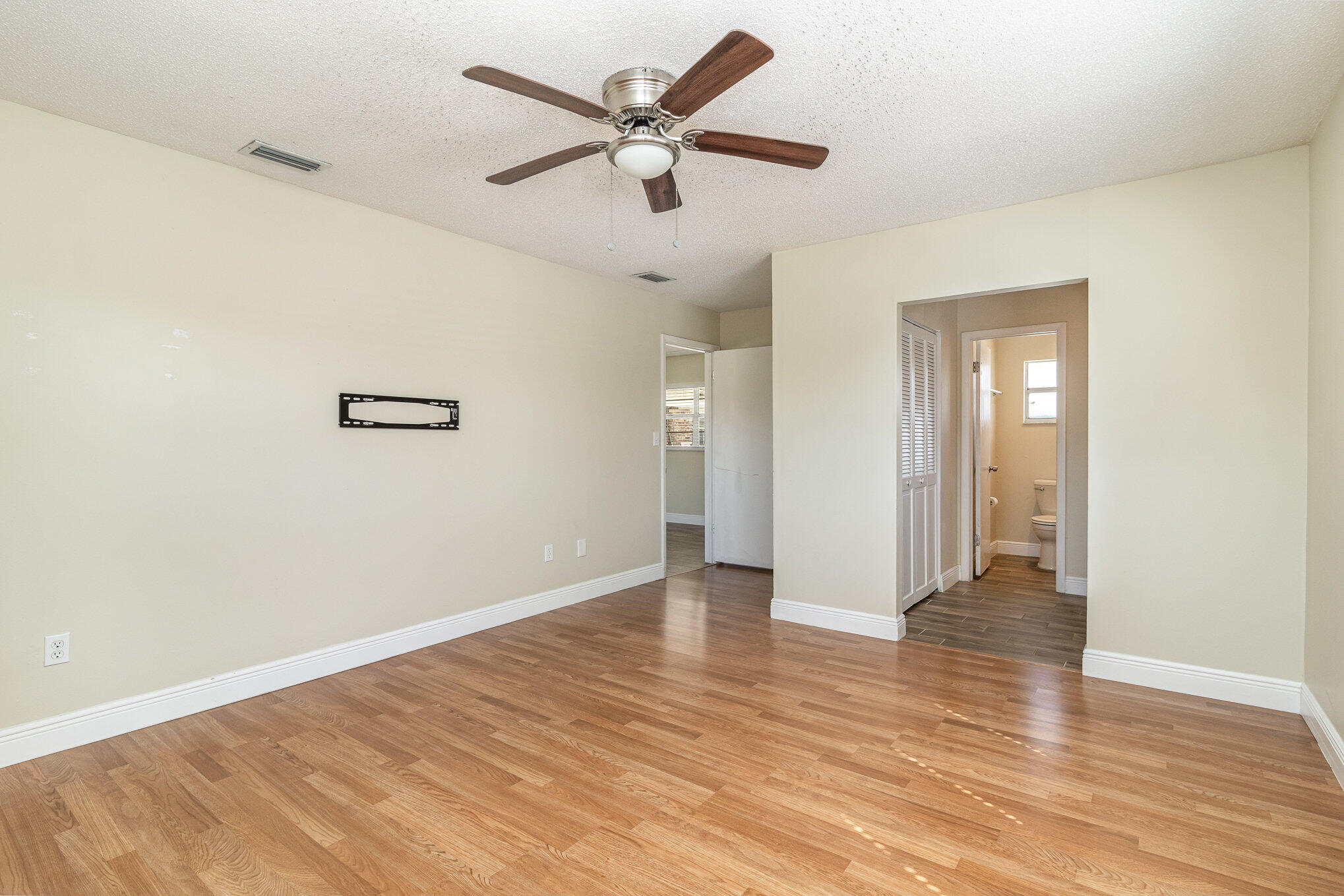 1294 Cimarron Circle Northeast Palm Bay, FL 32905 - Photo 21 of 45 an empty room with wooden floor and ceiling fan