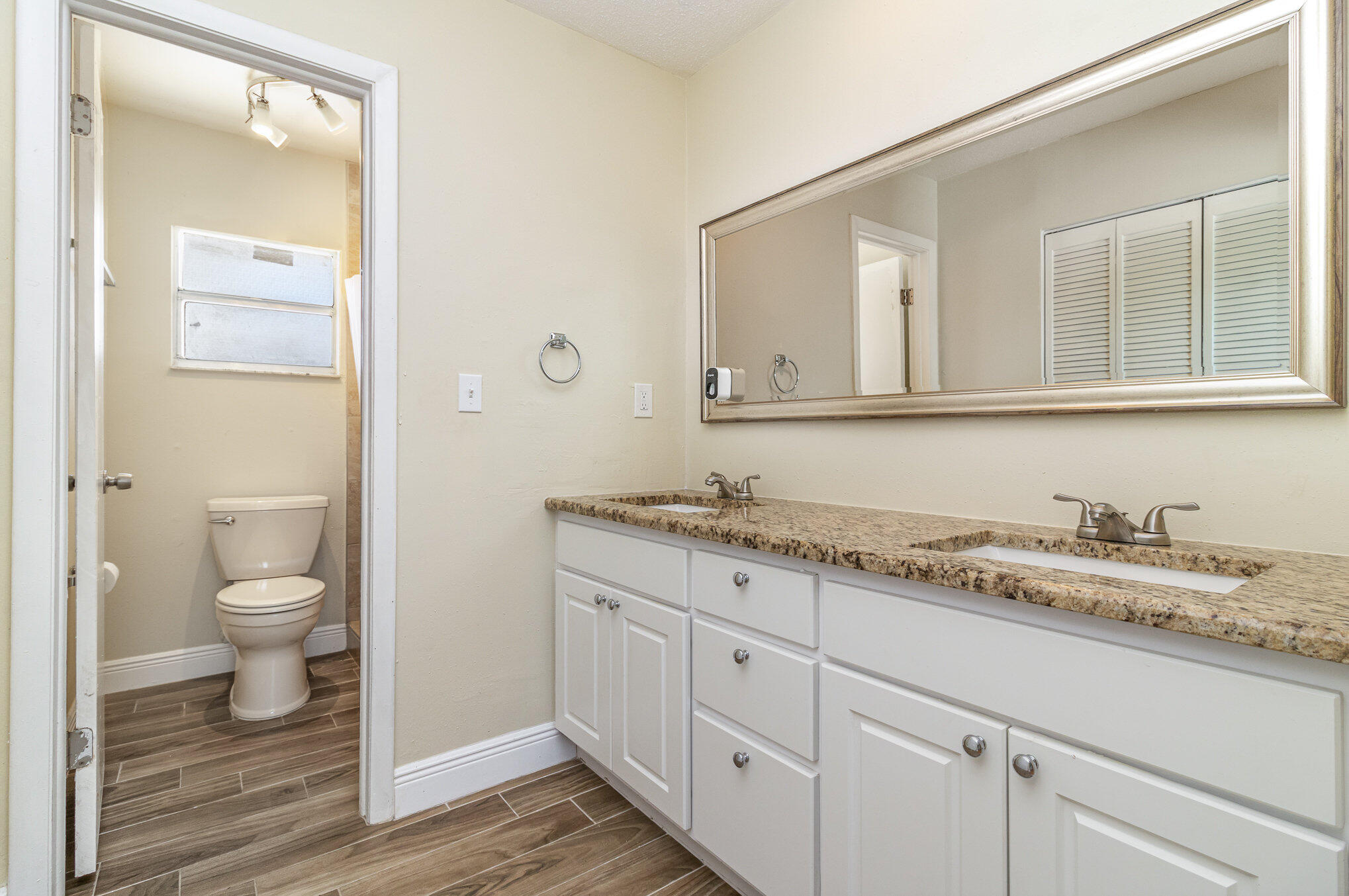 1294 Cimarron Circle Northeast Palm Bay, FL 32905 - Photo 23 of 45 a bathroom with a granite countertop toilet sink and mirror