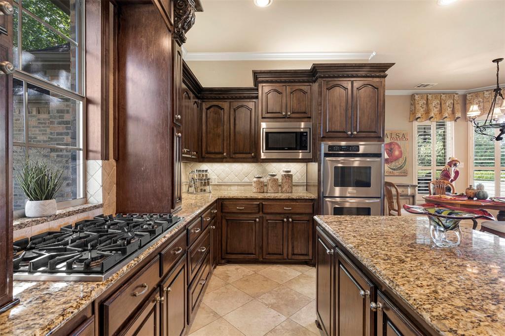 801 White Buffalo Lane Heath, TX 75032 - Photo 16 of 39 a kitchen with stainless steel appliances granite countertop a stove top oven a sink and a granite counter tops