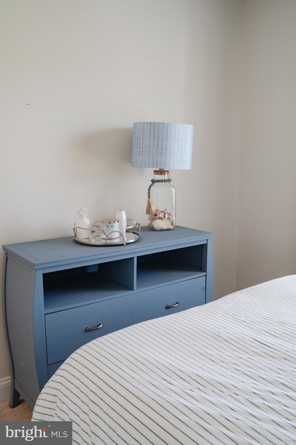 36046 Auburn Way Millsboro, DE 19966 - Photo 42 of 56 a bedroom with a bed and a lamp on table
